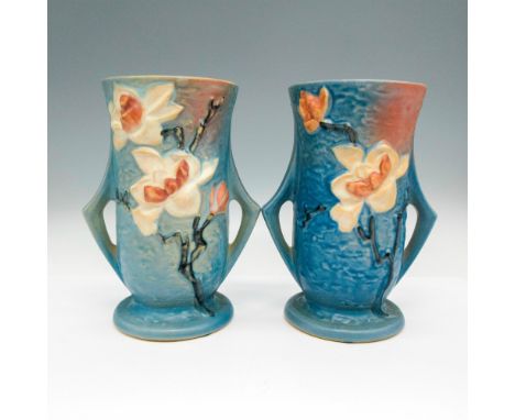 Cylinder shaped with low angled, double handles. Light glaze over blue with floral design in cream and light pink shades. Ros