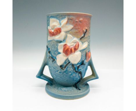 Cylinder shaped with low double handles. Light glaze over blue with floral design in cream and light pink shades. Roseville r