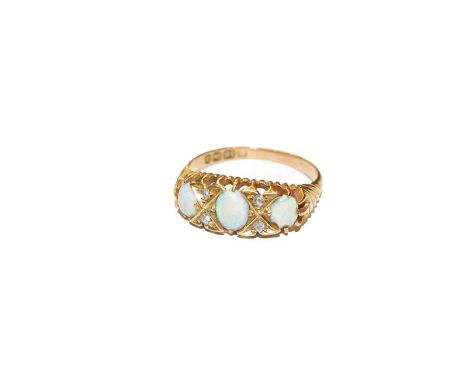 An 18 carat gold opal three stone ring, the graduated oval cabochon opals with rose cut diamond accents, in yellow claw setti