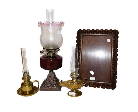 A carved oak serving tray, two Victorian brass based chamber lamps and an oil lamp with amethyst glass font (4)