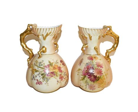 A pair of Royal Worcester ewers date code 1899, painted with flowers to a blush ground with gilt handles, 22cm high