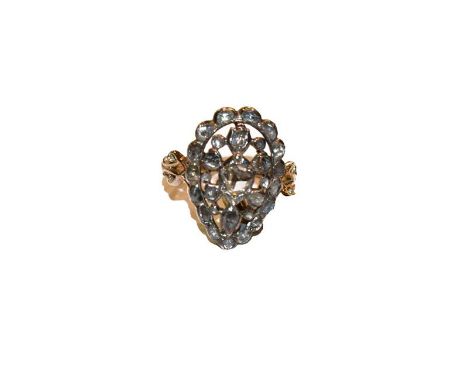 A diamond ring, the pear shaped pierced plaque set throughout with old cut and vari-cut diamonds, in white rubbed over settin