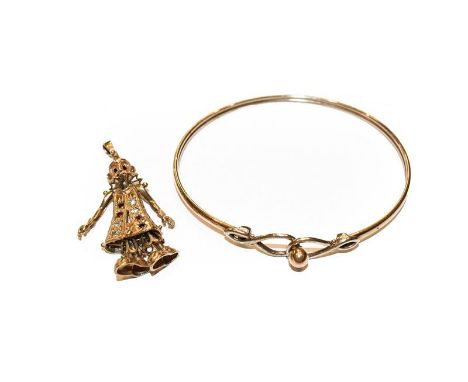 A 9 carat gold bangle, inner measurements 6.2cm by 5.2cm; and a 9 carat gold paste set articulated clown pendant, length 4.6c