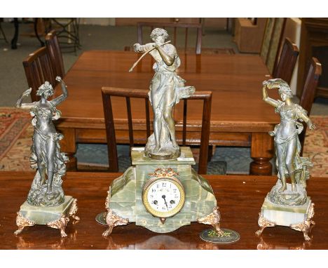 A green onyx and spelter figural striking mantle clock with garniture 