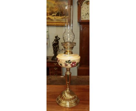 A Victorian brass based oil lamp with painted glass resivoir chimney, 46cm not including chimney