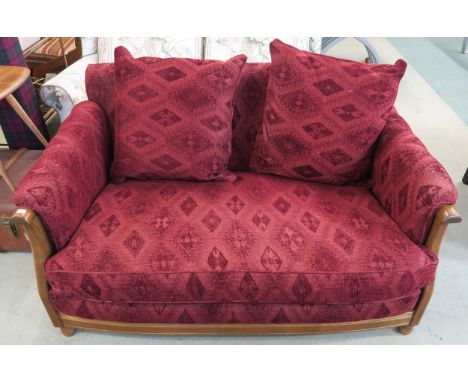 A 20th century beech framed Ercol two seater sofa with red patterned upholstery, 77cm high x 144cm wide x 95cm deep Condition