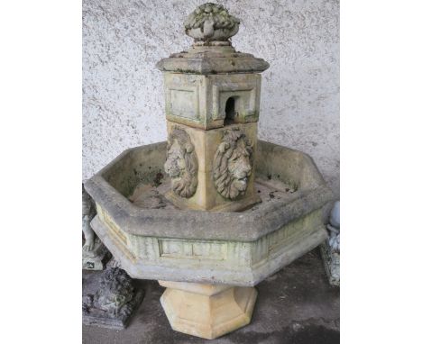 An octagonal stone garden water fountain with lion reliefs, 120cm high x 90cm wide x 90cm deep Condition Report:The fountain 