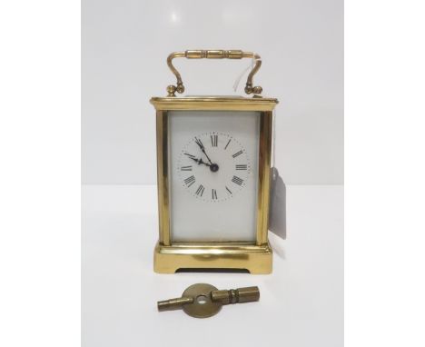 A brass carriage clock with white enamel dial and roman numeral chapter ring Condition Report:winds and ticks, has key, ename