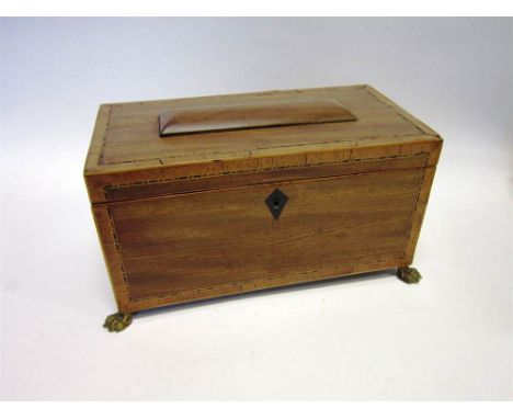 A 19TH CENTURY MAHOGANY TEA CADDY with line inlay, the two-division interior complete with inner covers, raised on cast brass