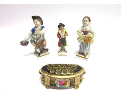 A PAIR OF SITZENDORF PORCELAIN FIGURINES depicting a boy wearing a blue coat, and a girl with a white scarf with red spots; a