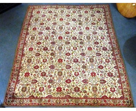 A RECTANGULAR BORDERED WOOL CARPET  on a beige ground with floral design, 410x320cm. (note: showing signs of wear)