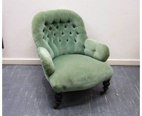 A VICTORIAN BUTTON BACK ARMCHAIR upholstered in sage green and on turned frontal supports