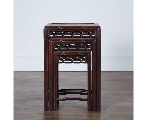 Nest of hardwood and burr wood occasional tablesChinese, circa 1900each with an interlaced carved frieze, largest 39cm wide, 