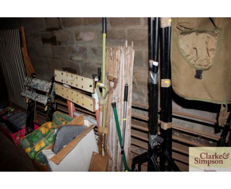 A collection of garden canes; long handled garden tools etc