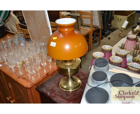 A brass oil lamp converted to a electric with amber glass shade