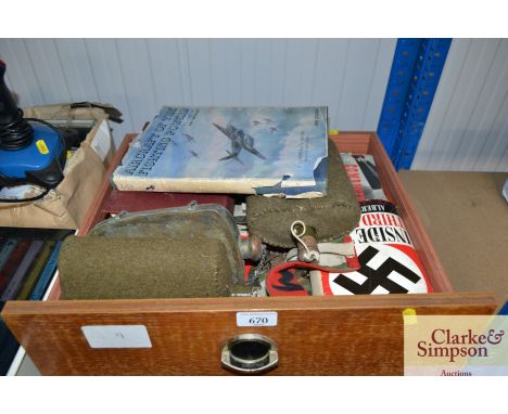 A box containing various military items to include a flask; books etc