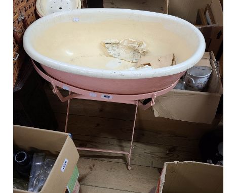 An old pink painted metal folding wash basin stand with painted liner and soap dish