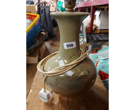 A ceramic table lamp with gilt decoration on a green glazed ground