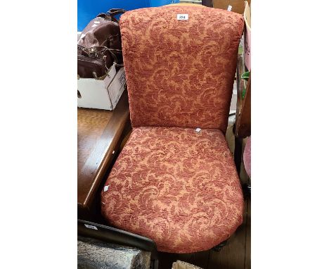 A Victorian boudoir standard chair with red machine tapestry upholstery, set on turned legs and later casters