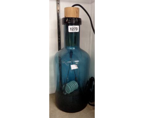 A dark blue glass bottle vase with internal lamp fitting