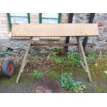 A wooden saddle rack, set on A-frame base