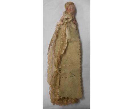 A small bisque porcelain doll with painted features and lace clothing - clothing tatty