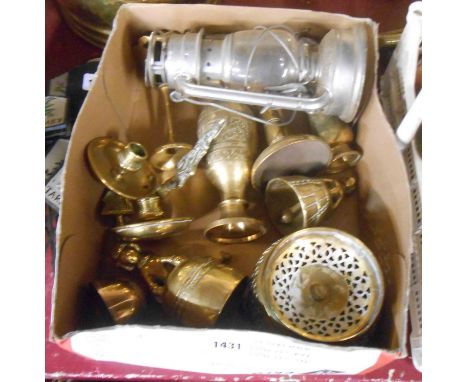 A box containing various brass items including a pair of Punch and Judy candle holders, three brass bells, a Kwang tilly lamp
