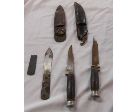 A bag containing two hunting style knives, leather sheaves and another
