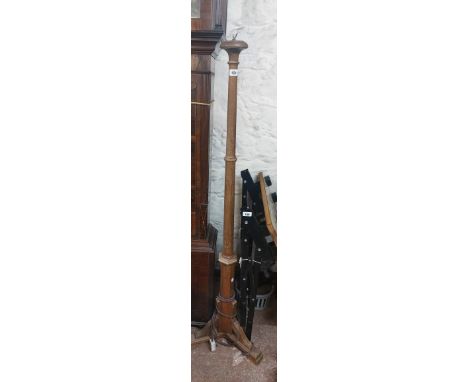 A vintage oak standard lamp with turned pillar and bracketed tripod base