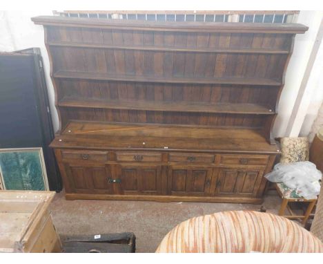 A 2.44m 20th Century stained oak two part dresser in the antique style with three shelf open plate rack over a base with four