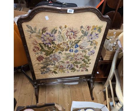 An early 20th Century stained wood framed fire screen with woolwork floral tapestry panel