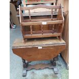 A vintage oak drop-leaf table, set on flanking turned pillars - sold with a magazine rack