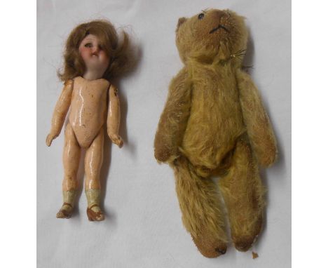 An antique miniature Teddy Bear with jointed limbs and glass bead eyes - sold with a miniature doll with porcelain head and c