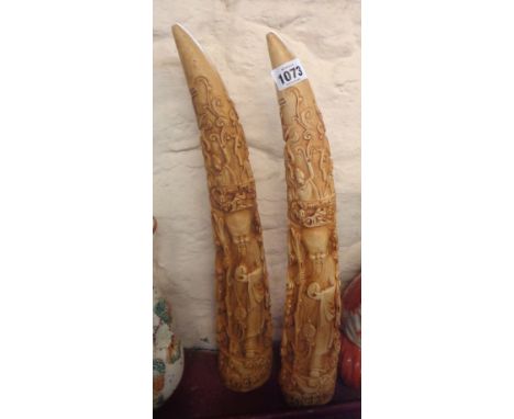 A pair of large cast resin tusk ornaments with Chinese style decoration