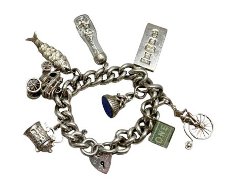 A silver charm bracelet with silver and white metal charms including an articulated fish, an ingot, etc., 107g