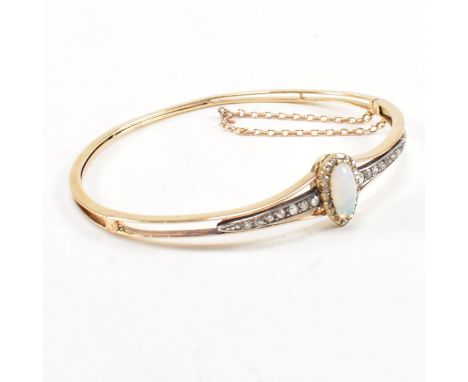 A cased early late Victorian Edwardian opal and diamond hinged bangle. The bangle having a pear cut opal framed by rose cut d