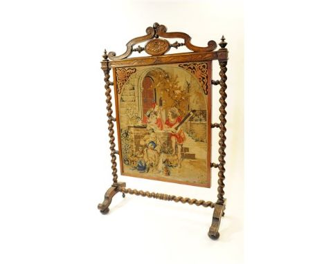 A Victorian walnut framed fire screen with elaborate broken scroll pediment centred by an oval patera motif above a tapestry 