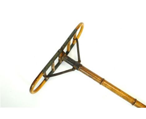 An Edwardian shooting stick/seat, the bamboo stem supporting a butterfly hinged splatted seat, 37cm wide when open, 76cm long