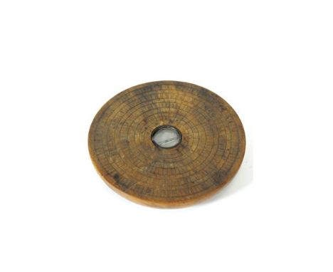 A mid-late 19 th century Chinese compass, the stained and incised wooden base accommodating a simple central glass with metal