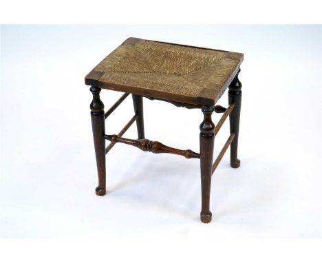 A 19th century rush seated stool, the rectangular top raised on four turned tapering cabriole legs united by turned spindle s