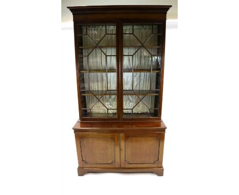 A Victorian mahogany bookcase, the astragal glazed panelled doors enclosing a shelved interior below a dental cornice, above 