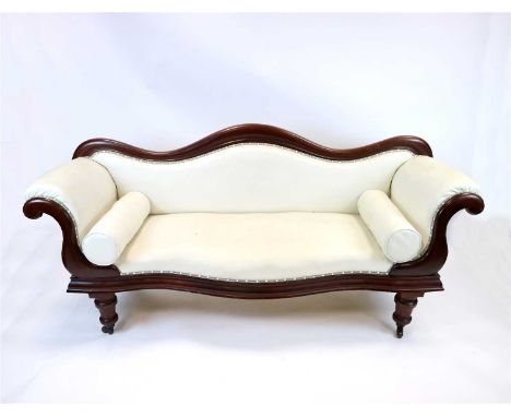 A Victorian mahogany serpentine framed upholstered sofa, with a shaped back, scrolling arms and set raised on turned legs and