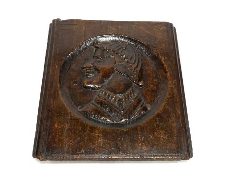 An early oak carved panel detailing a figure presented in side profile, the figure of stylised proportions wearing a decorati
