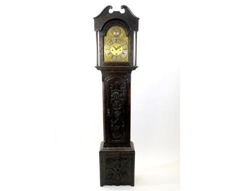 A George III cottage long case clock, later carved, the broken scroll pediment above an arched glazed door flanked by plain p