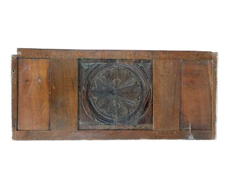 A section of 18th century and later oak panelling, centred with a shallow carved stylised foliate panel, framed in a later pa