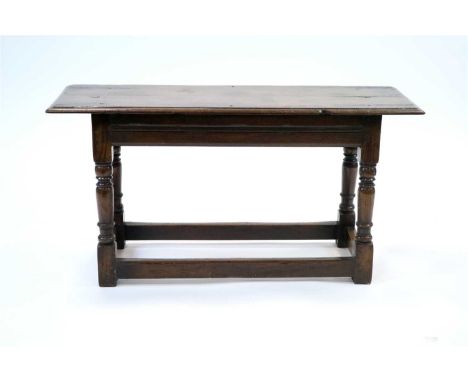 An old country oak window seat or hall stool, the plank top with a carved border raised on four turned legs united by plain s