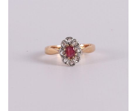 An 18 kt 750/1000 gold entourage ring with an oval facet-cut ruby and 8 rose-cut diamonds. Early 20th century. Ring size Ø 18