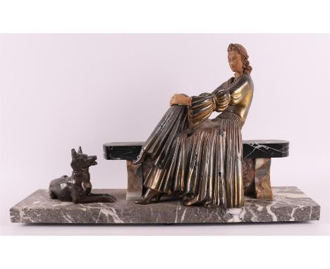 A white metal Art Deco sculpture of a lady on a sofa with a dog at her side, France, ca. 1920, h 24 x w 39 cm (restoration on