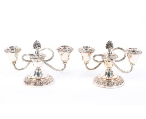 A pair of silver-plated twin-light candelabra, 20th century, with reeded whiplash branches, flame finial and leaf cast border