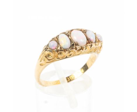 An 18ct gold and opal ring, set with graduated line of oval cut opals to a scrolling setting. 1.6g. Size P. 